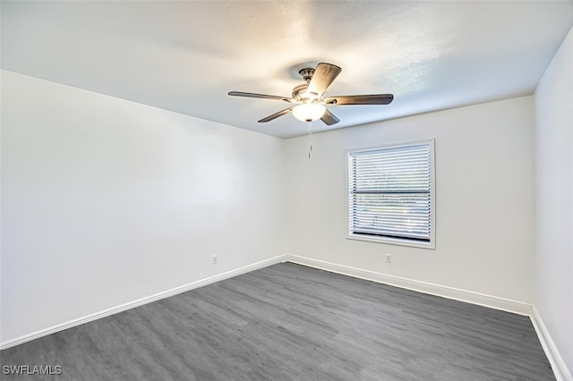 spare room featuring ceiling fan and dark wood-type flooring