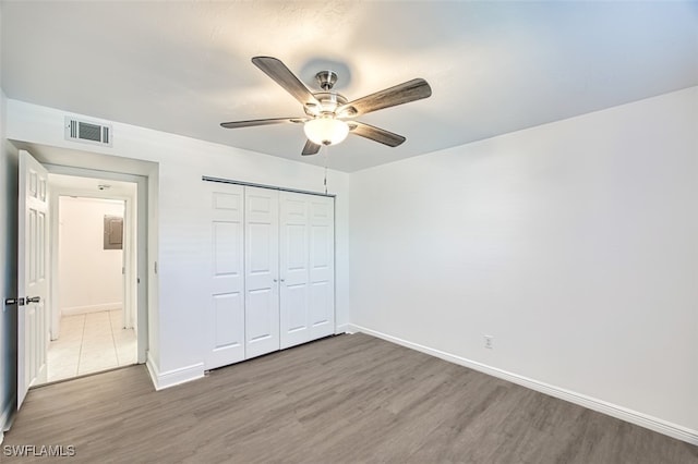 unfurnished bedroom featuring ceiling fan, a closet, and wood-type flooring