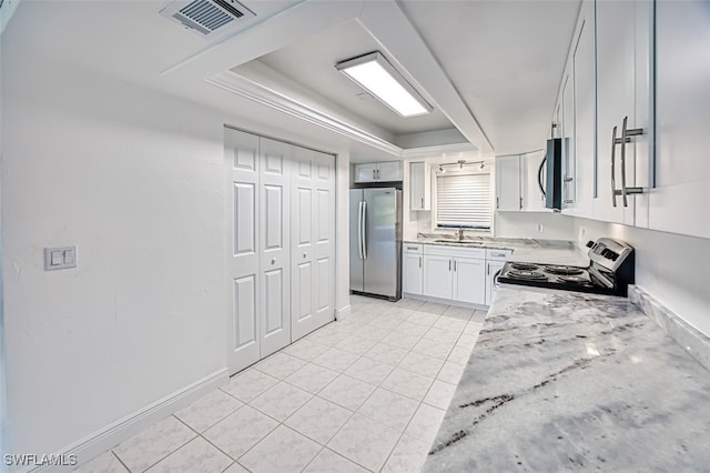 kitchen with white cabinetry, sink, stainless steel appliances, a raised ceiling, and light stone counters