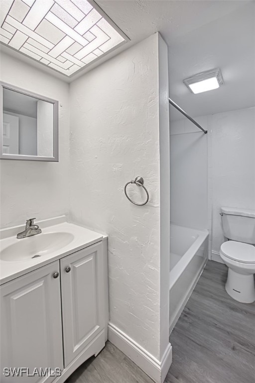 full bathroom with hardwood / wood-style floors, vanity, toilet, and shower / tub combination