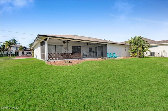 back of house with a sunroom, ceiling fan, and a lawn