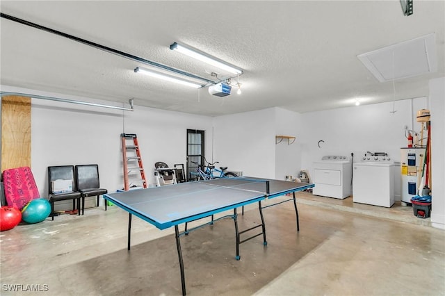 playroom with concrete flooring, water heater, washer and dryer, and a textured ceiling