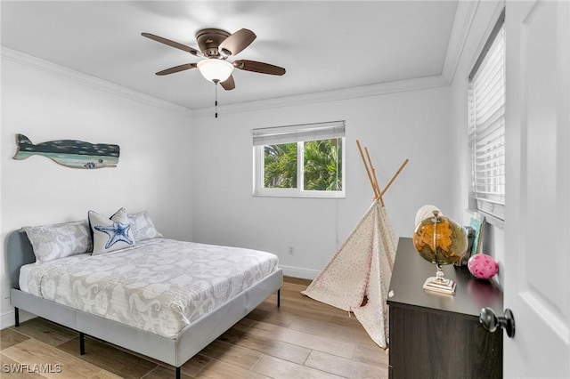 bedroom with ceiling fan, light hardwood / wood-style floors, and ornamental molding