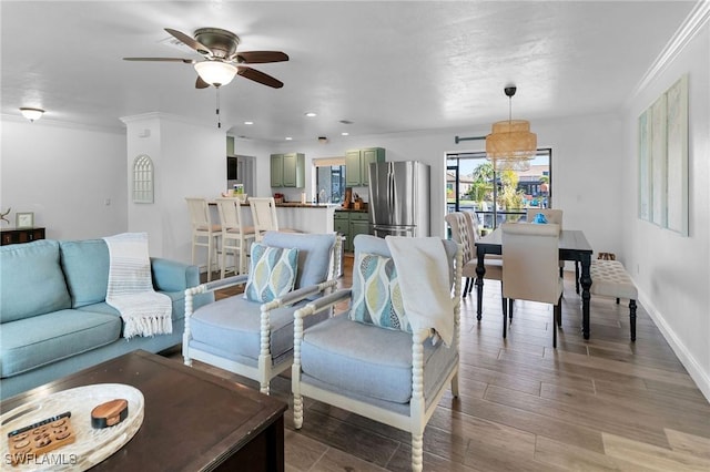 living room featuring hardwood / wood-style floors, ceiling fan, and ornamental molding