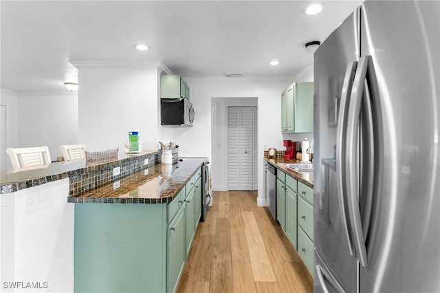 kitchen with green cabinets and stainless steel appliances