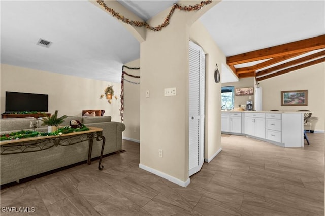 corridor with vaulted ceiling with beams