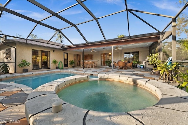 view of swimming pool with a patio area, ceiling fan, and glass enclosure