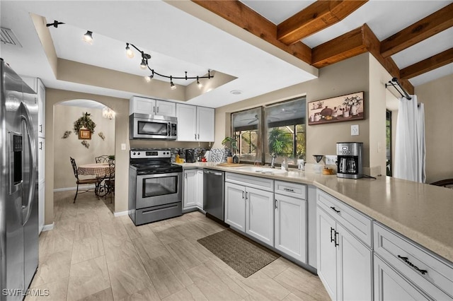 kitchen featuring kitchen peninsula, sink, white cabinets, and stainless steel appliances