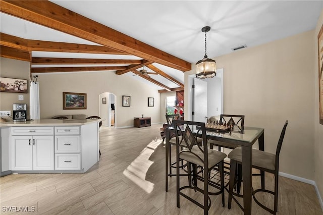 dining space featuring vaulted ceiling with beams and ceiling fan