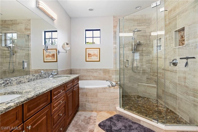 bathroom featuring vanity and independent shower and bath