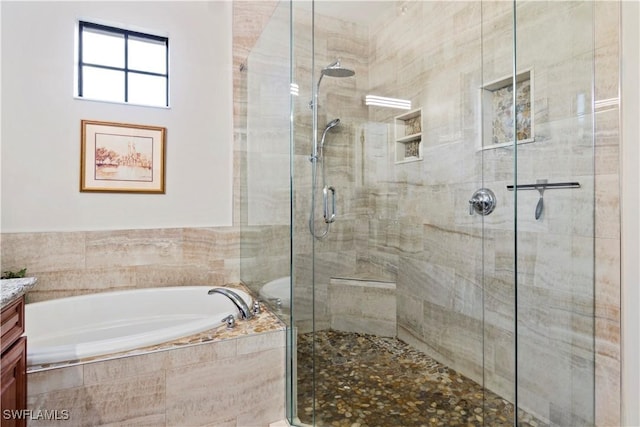 bathroom featuring vanity and shower with separate bathtub