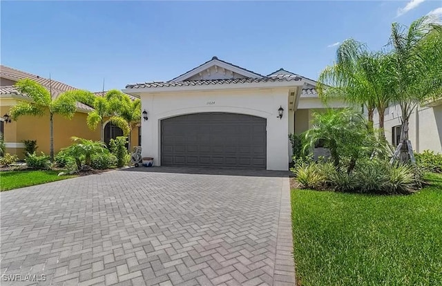 mediterranean / spanish-style house with a front yard and a garage