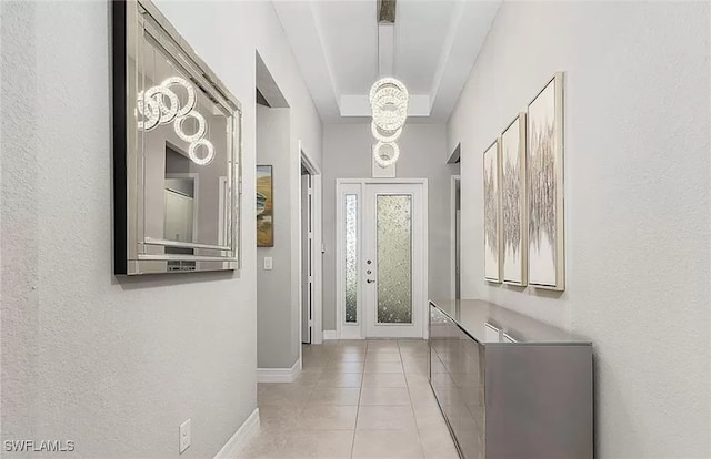 entrance foyer with light tile patterned floors and an inviting chandelier