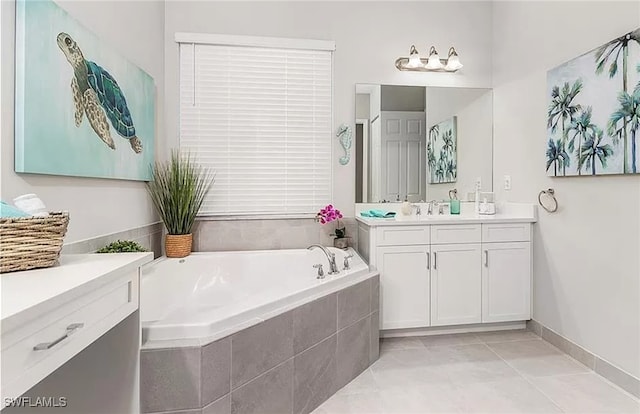 bathroom featuring tile patterned flooring, vanity, and tiled tub