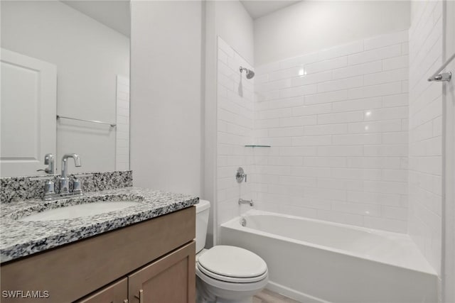 full bathroom featuring vanity, tiled shower / bath combo, and toilet