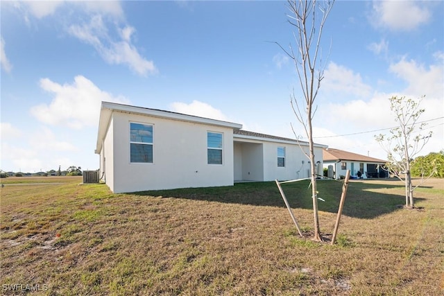 rear view of house with a yard and central AC unit