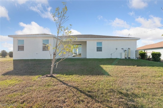 rear view of house featuring a lawn