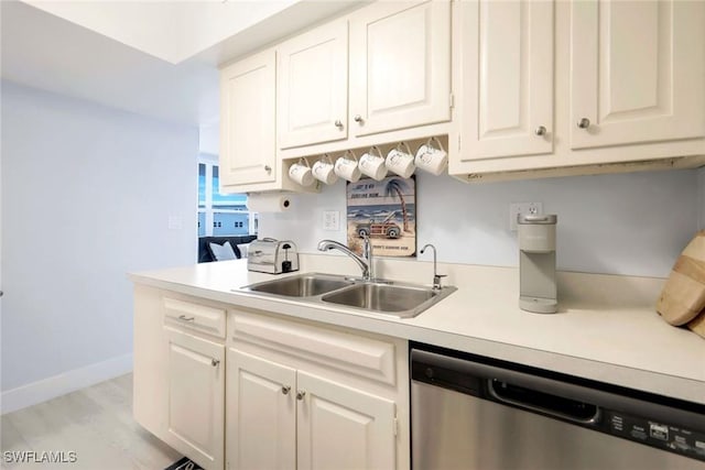 kitchen with white cabinetry, sink, stainless steel dishwasher, and light hardwood / wood-style flooring