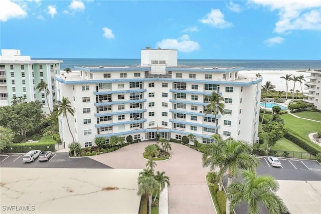 view of building exterior with a water view and a view of the beach