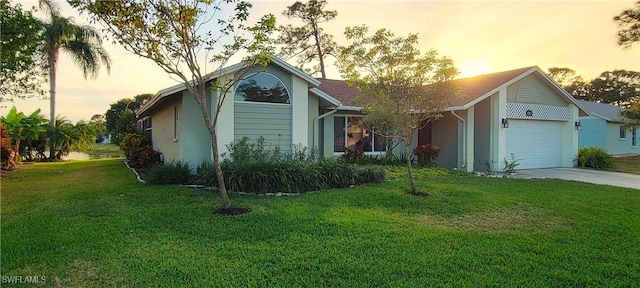 ranch-style house featuring a yard and a garage