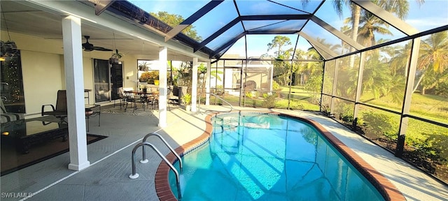 view of swimming pool with ceiling fan, a lanai, and a patio