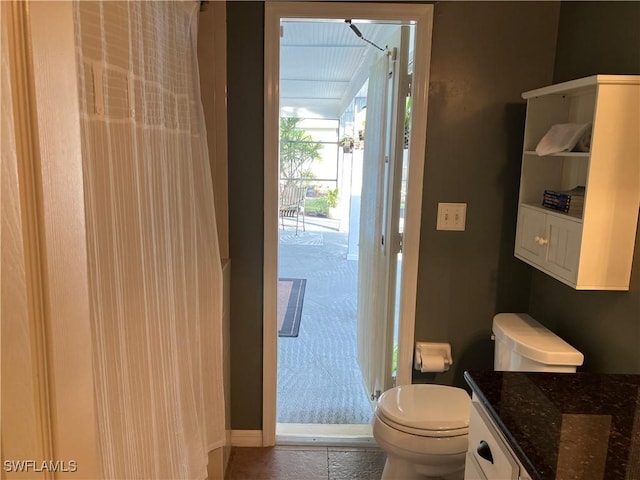 bathroom with walk in shower, vanity, and toilet