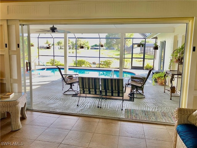 sunroom featuring ceiling fan and a swimming pool