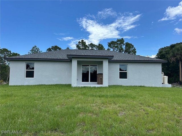 rear view of property featuring a yard