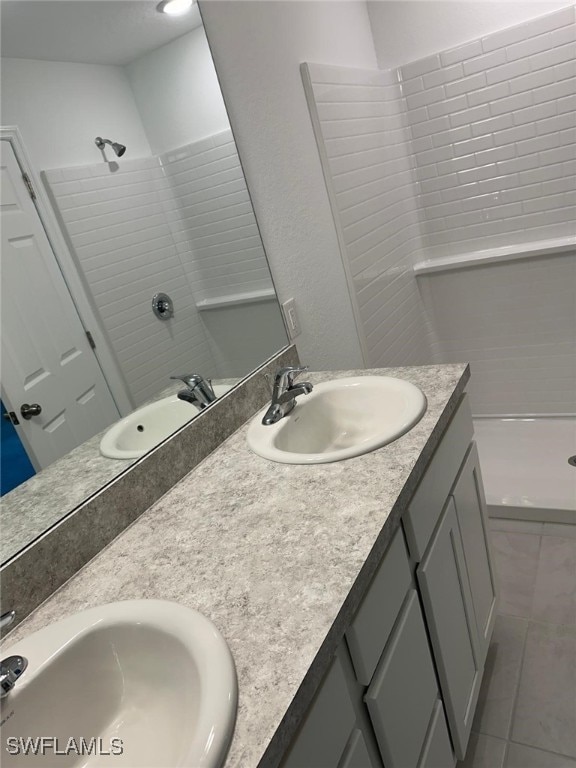 bathroom with tile patterned flooring, vanity, and walk in shower