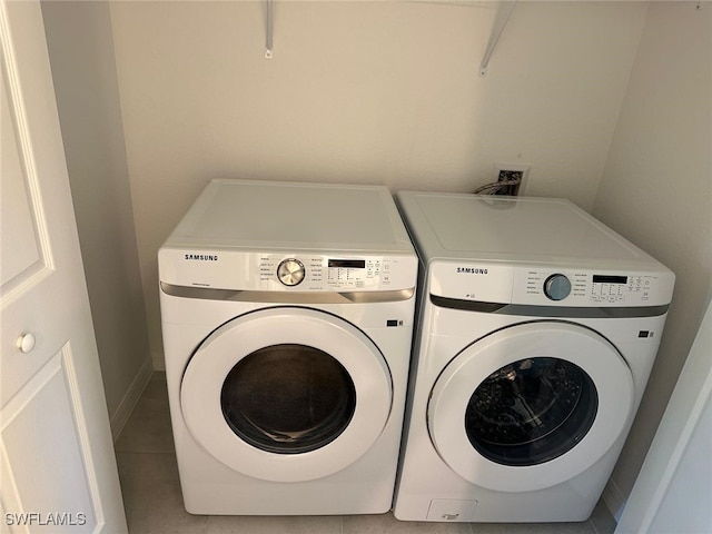 laundry room with tile patterned floors and washing machine and clothes dryer