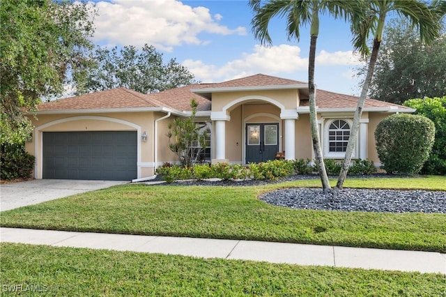 mediterranean / spanish-style home with a front yard and a garage