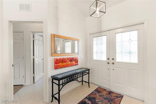 tiled entrance foyer with a chandelier