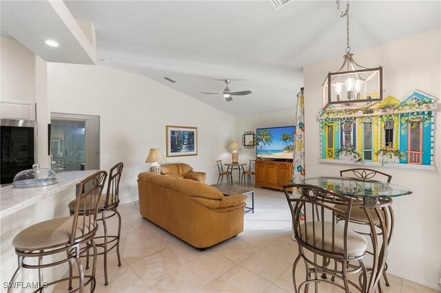 living room featuring lofted ceiling, light tile patterned floors, and ceiling fan with notable chandelier