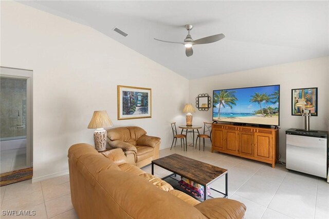 living room with ceiling fan, lofted ceiling, and light tile patterned flooring