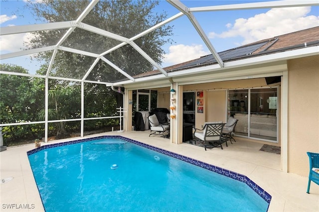 view of swimming pool with glass enclosure and a patio area