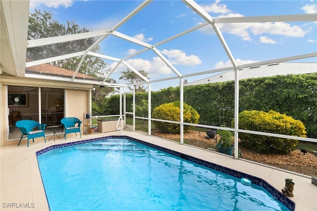 view of pool with glass enclosure and a patio area