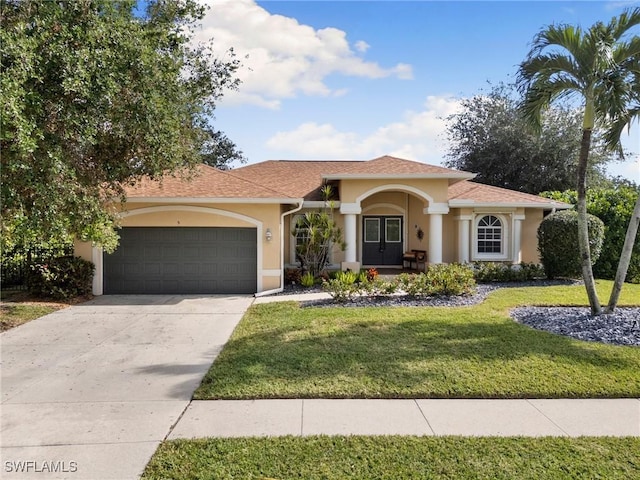 mediterranean / spanish home with a front yard and a garage