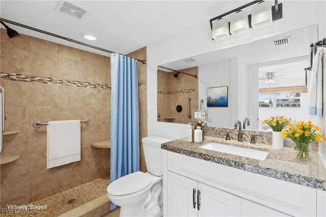 bathroom with a shower with curtain, ceiling fan, vanity, and toilet