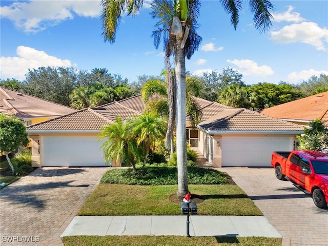 mediterranean / spanish-style home featuring a garage and a front yard