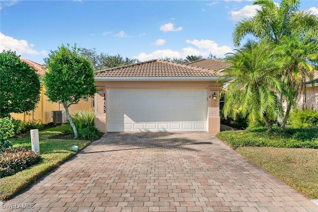 view of front of property featuring a garage and central AC unit