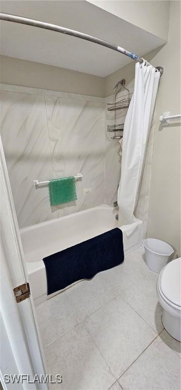 bathroom with shower / bath combo with shower curtain, tile patterned flooring, and toilet