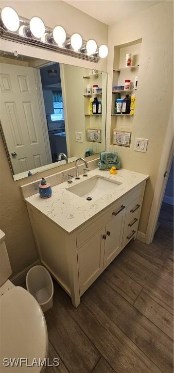 bathroom featuring vanity, hardwood / wood-style flooring, and toilet