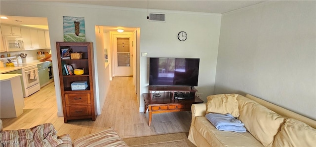 living room with light hardwood / wood-style floors and ornamental molding