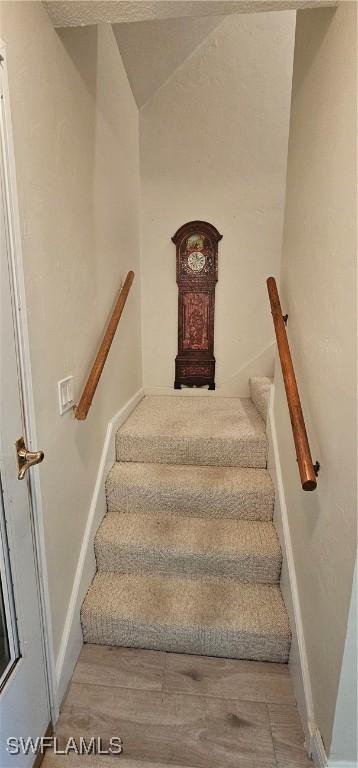 staircase featuring lofted ceiling