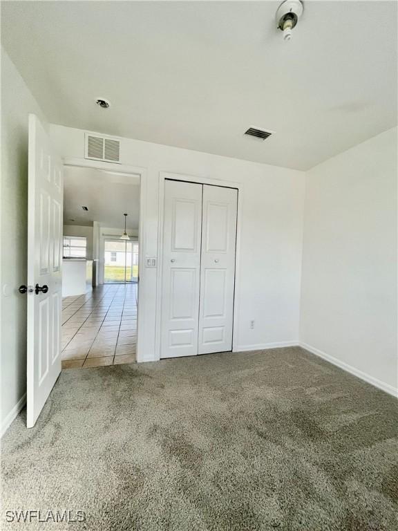 unfurnished bedroom with carpet and a closet