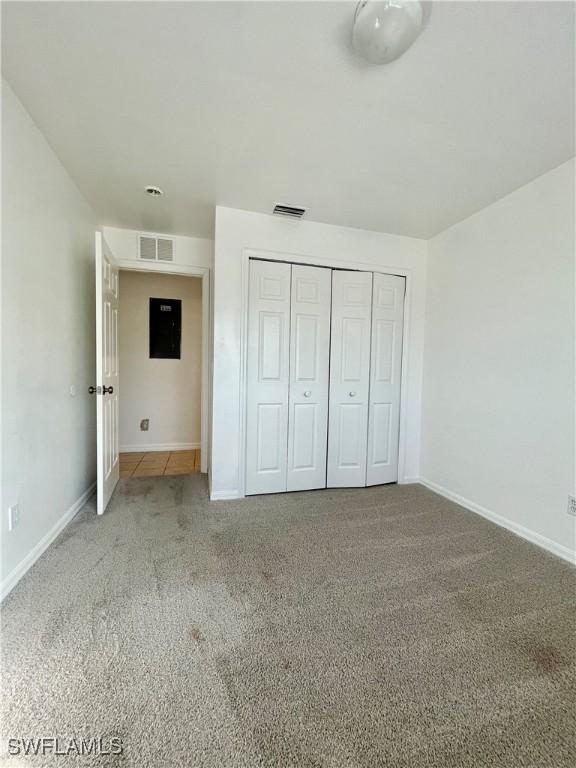 unfurnished bedroom featuring carpet and a closet