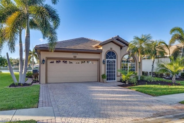 mediterranean / spanish home with a garage and a front lawn