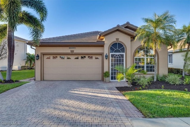 mediterranean / spanish house featuring a garage and a front yard