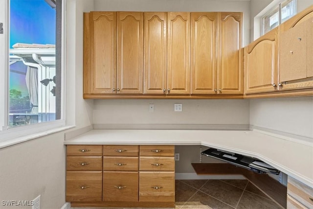 unfurnished office featuring a wealth of natural light and tile patterned floors