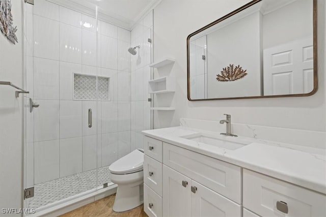 bathroom featuring ornamental molding, toilet, a shower stall, and vanity